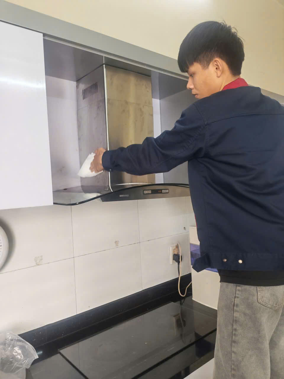 Kỹ thuật viên kiểm tra và vệ sinh máy hút mùi tại nhà